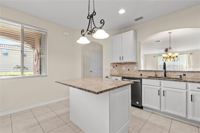 kitchen with a healthy amount of sunlight, a center island, stainless steel dishwasher, and sink