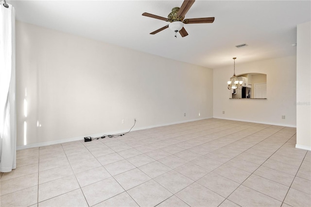 empty room with ceiling fan with notable chandelier and light tile patterned floors