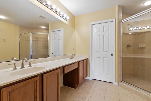 bathroom featuring tile patterned flooring, vanity, and a shower with door