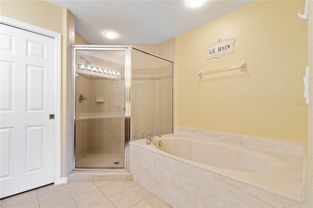 bathroom with tile patterned floors and shower with separate bathtub