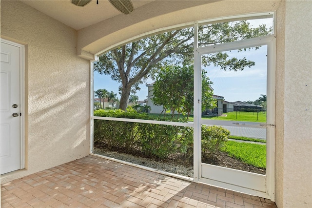 unfurnished sunroom featuring ceiling fan