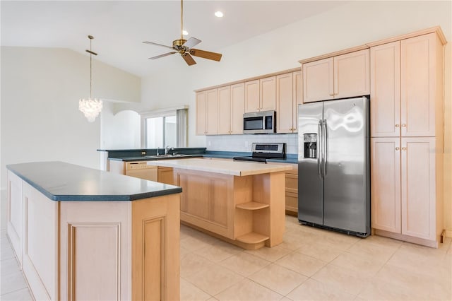 kitchen featuring light tile flooring, tasteful backsplash, a center island, stainless steel appliances, and ceiling fan with notable chandelier