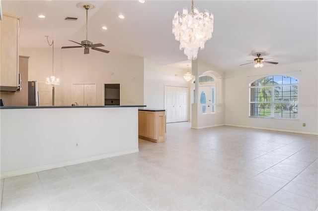 interior space with high vaulted ceiling, ceiling fan with notable chandelier, and light tile floors