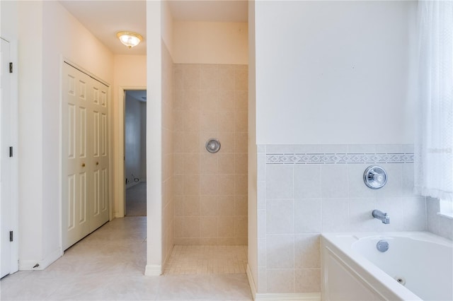 bathroom with a bath to relax in and tile flooring