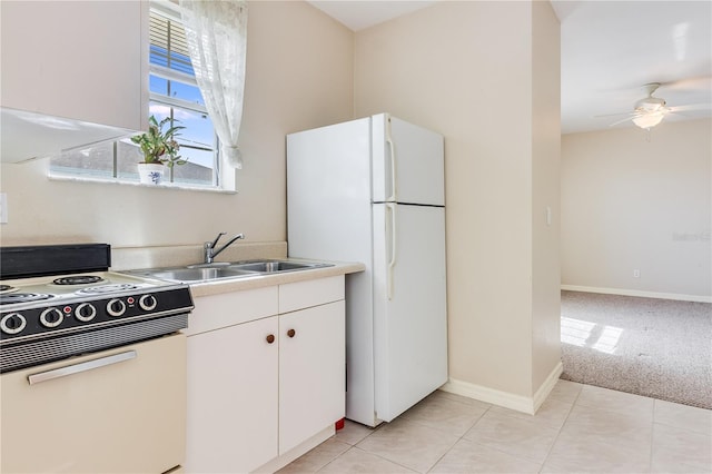 kitchen with ceiling fan, white appliances, sink, white cabinets, and light colored carpet