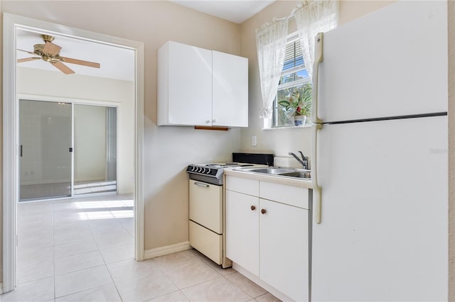 kitchen with white appliances, ceiling fan, light tile floors, sink, and white cabinets