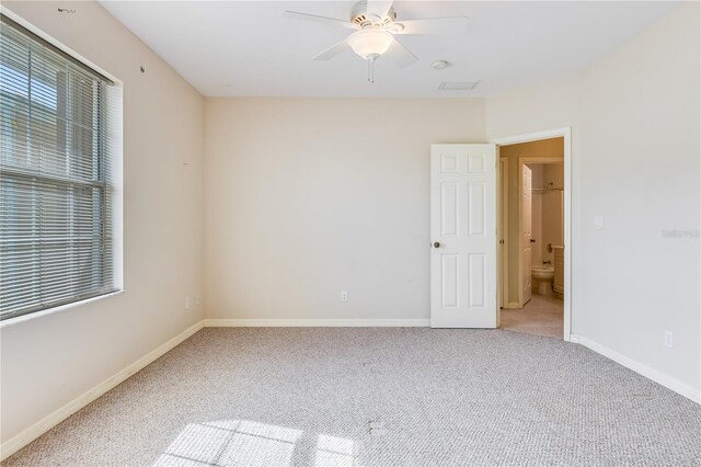 spare room with ceiling fan and light carpet