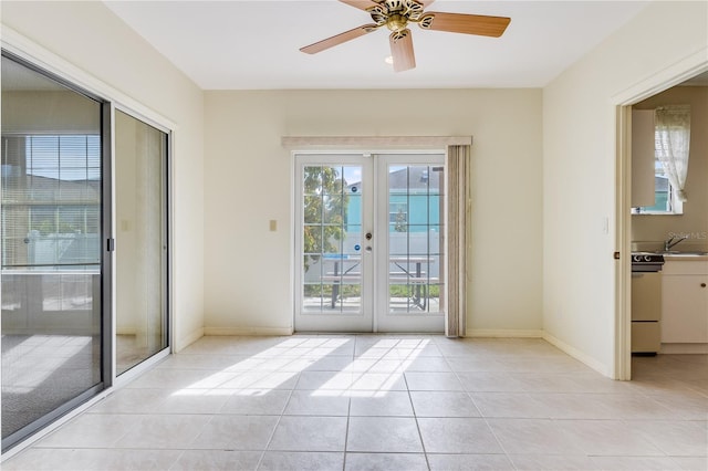 spare room featuring light tile floors, ceiling fan, french doors, and sink