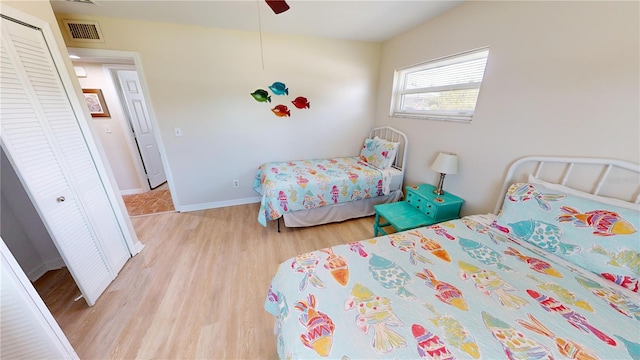 bedroom featuring ceiling fan, light hardwood / wood-style floors, and a closet