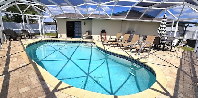 view of swimming pool with a lanai and a patio area