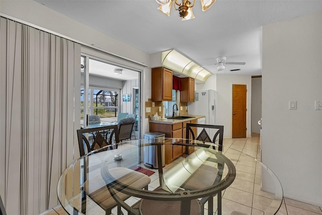 dining room featuring ceiling fan with notable chandelier, sink, and light tile patterned floors