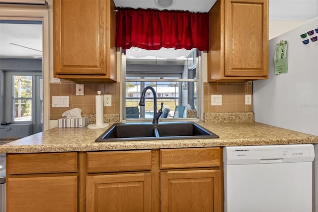 kitchen with sink, backsplash, and white dishwasher