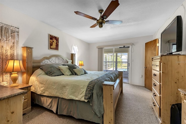 bedroom featuring ceiling fan, access to exterior, light colored carpet, and a textured ceiling