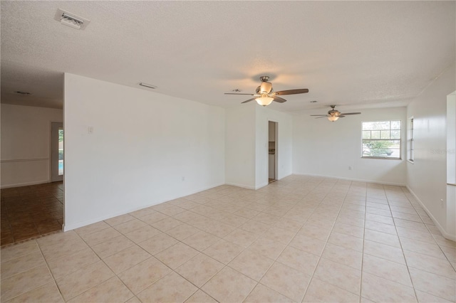 spare room featuring light tile patterned floors, a textured ceiling, and ceiling fan