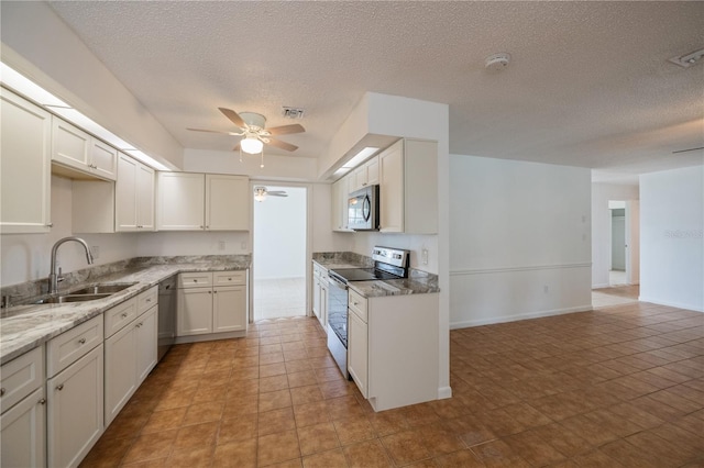 kitchen with white cabinetry, sink, stainless steel appliances, a textured ceiling, and light tile patterned floors