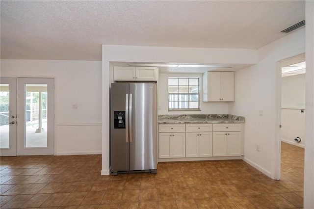 kitchen featuring plenty of natural light, white cabinetry, french doors, and stainless steel refrigerator with ice dispenser