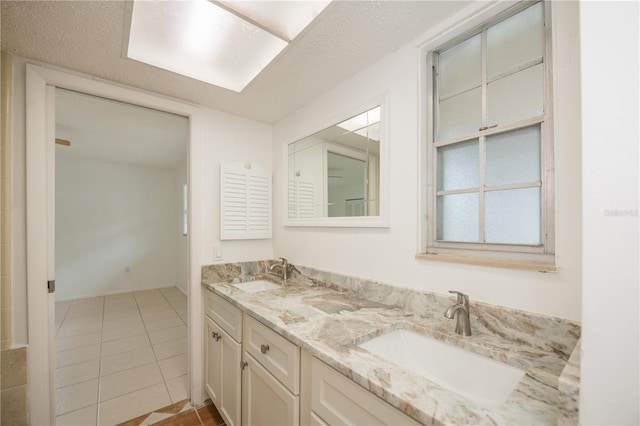 bathroom featuring tile patterned flooring, vanity, and a textured ceiling