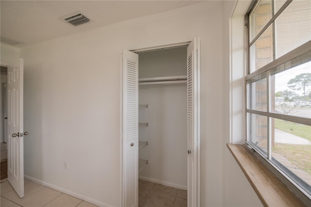 interior space with a closet and light tile patterned floors