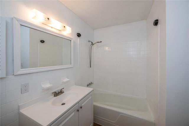 bathroom featuring tiled shower / bath, vanity, tasteful backsplash, and tile walls