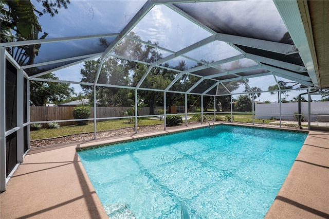 view of swimming pool featuring a lanai and a patio