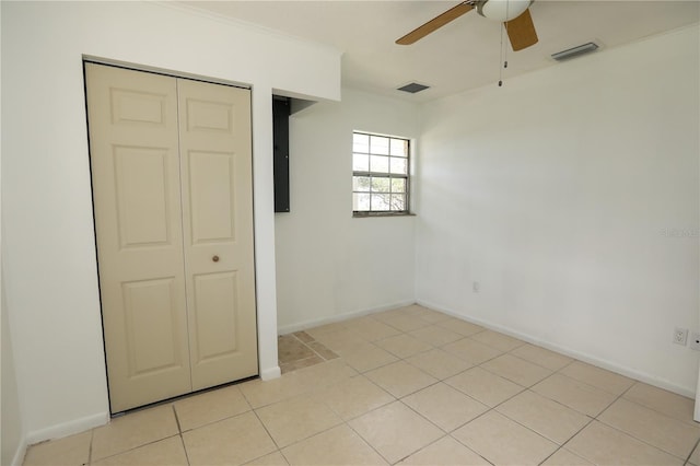 unfurnished bedroom with ceiling fan, light tile patterned floors, and a closet