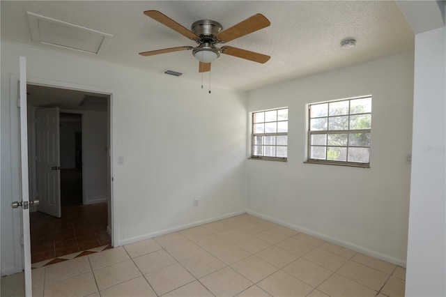 unfurnished room with ceiling fan, light tile patterned flooring, and a textured ceiling