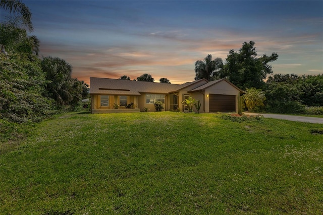 ranch-style house featuring a lawn and a garage