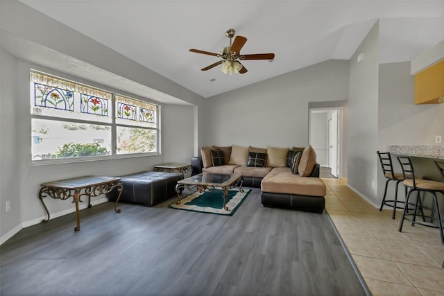 tiled living room featuring ceiling fan and lofted ceiling