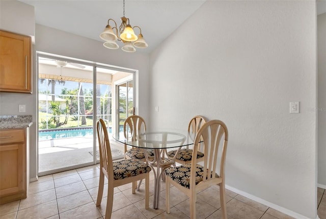 tiled dining area featuring vaulted ceiling and a chandelier