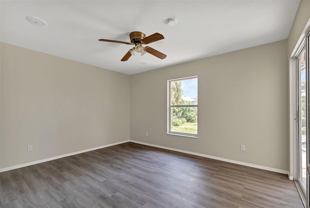 empty room with ceiling fan and dark hardwood / wood-style flooring