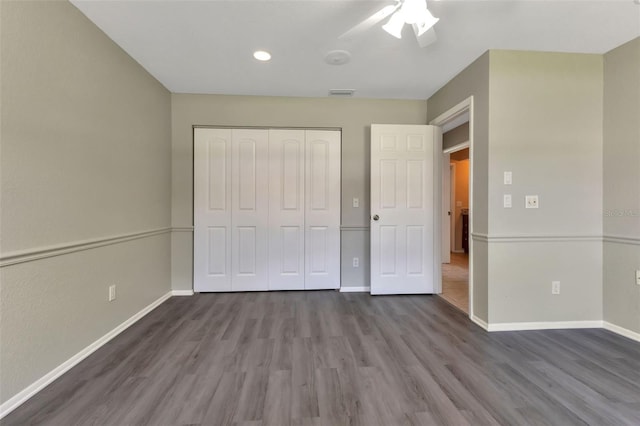 unfurnished bedroom with ceiling fan, a closet, and dark wood-type flooring