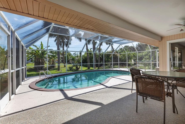 view of swimming pool featuring a patio, ceiling fan, and glass enclosure