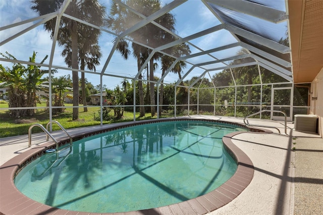 view of pool featuring glass enclosure and a patio