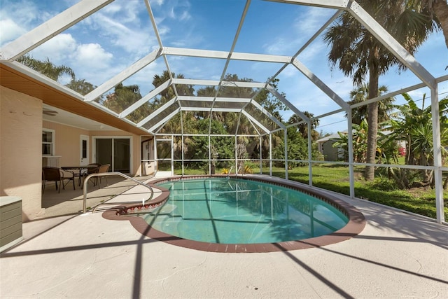 view of pool with a patio and glass enclosure