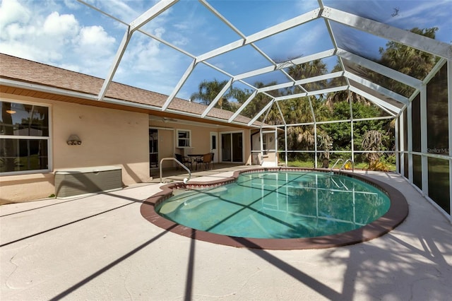 view of pool featuring glass enclosure and a patio