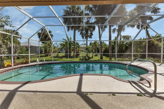 view of pool featuring glass enclosure and a patio