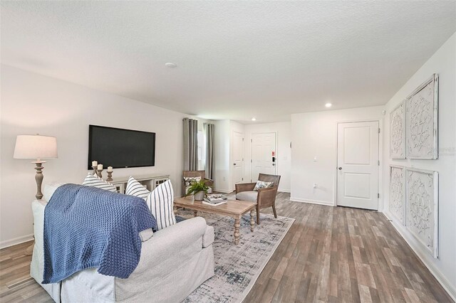 living room featuring a textured ceiling and dark wood-type flooring