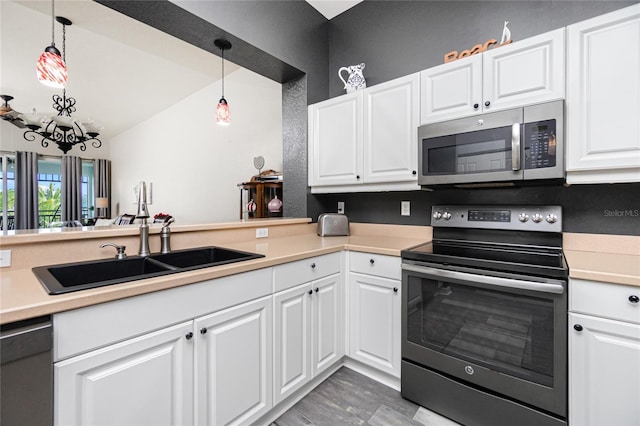 kitchen with white cabinets, decorative light fixtures, and appliances with stainless steel finishes