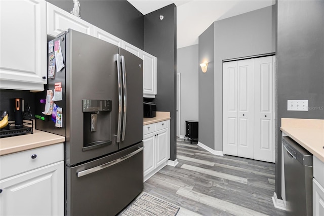 kitchen featuring appliances with stainless steel finishes, light hardwood / wood-style flooring, and white cabinetry