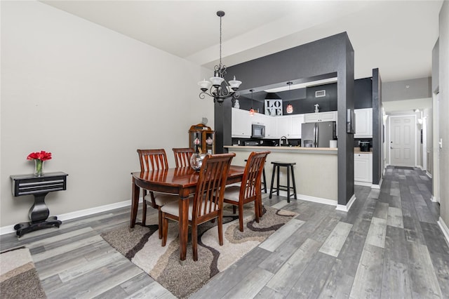 dining area with a chandelier and wood-type flooring