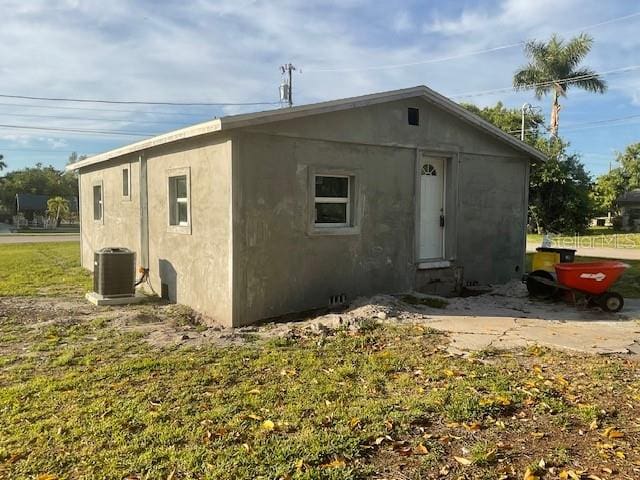 rear view of house with a lawn and central air condition unit