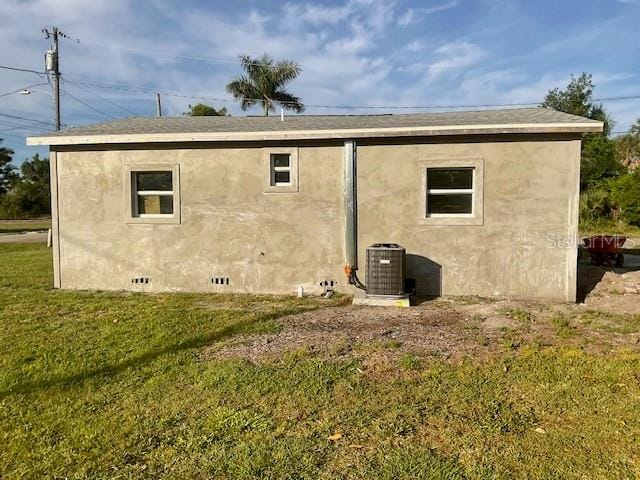 back of house featuring a lawn and central AC