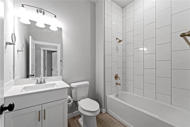 full bathroom with toilet, tiled shower / bath combo, vanity, and hardwood / wood-style floors