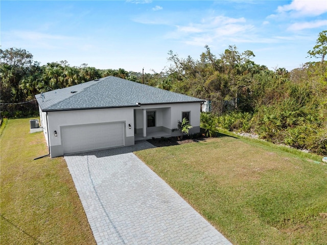 view of front of house with central air condition unit, a garage, and a front yard