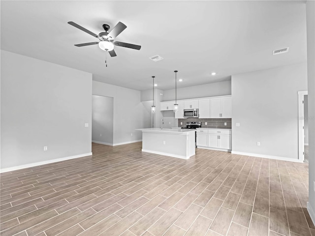 unfurnished living room featuring ceiling fan, sink, and light hardwood / wood-style flooring