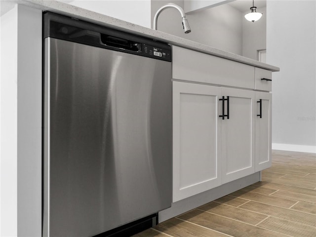 kitchen with dishwasher, decorative light fixtures, light hardwood / wood-style floors, and white cabinets