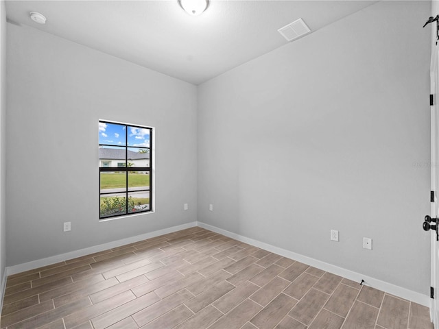 unfurnished room featuring a barn door and light wood-type flooring