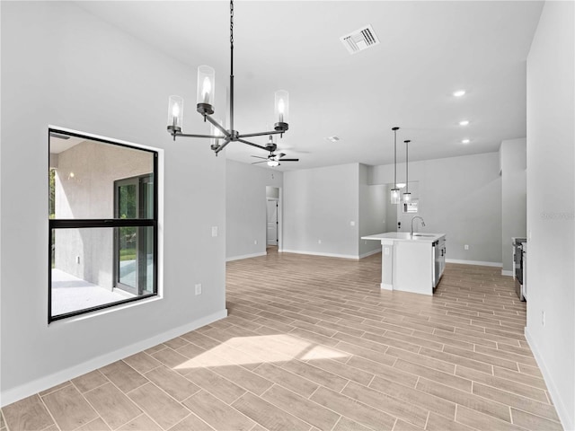 unfurnished living room with ceiling fan with notable chandelier, sink, and light wood-type flooring