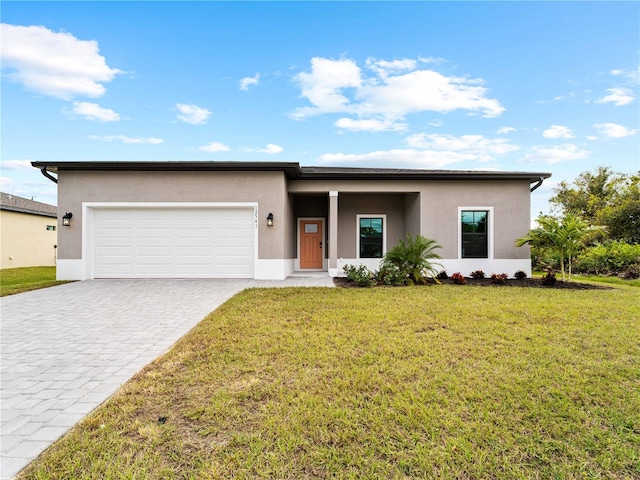 view of front of home with a garage and a front lawn