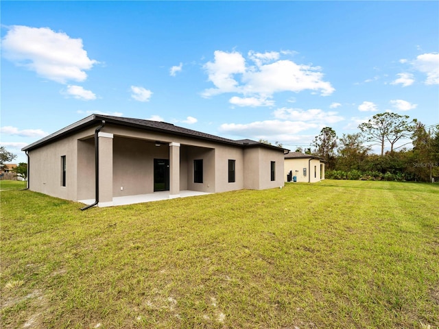 back of house featuring a lawn and a patio area